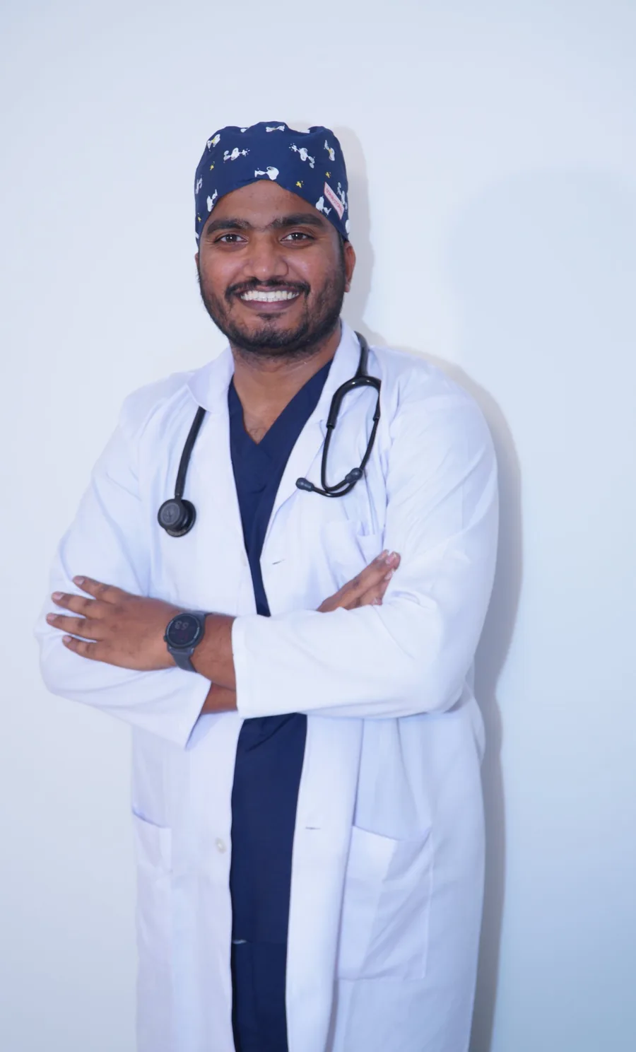 Dr. Akif in scrubs and a surgical cap, arms crossed
